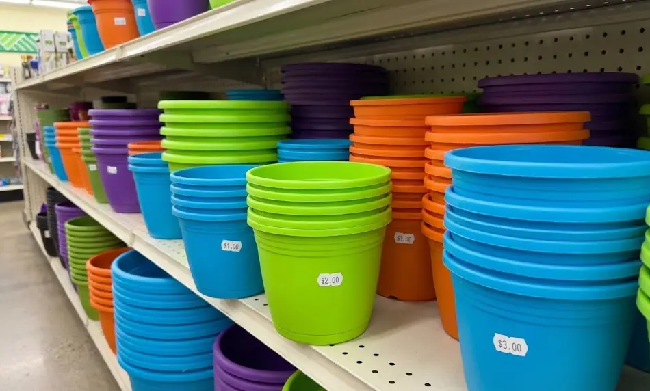 Retail shelves stocked with stacks of bright green, blue, and orange plastic plant pots, with visible price stickers showing $1.00, $2.00, and $3.00 price points.
